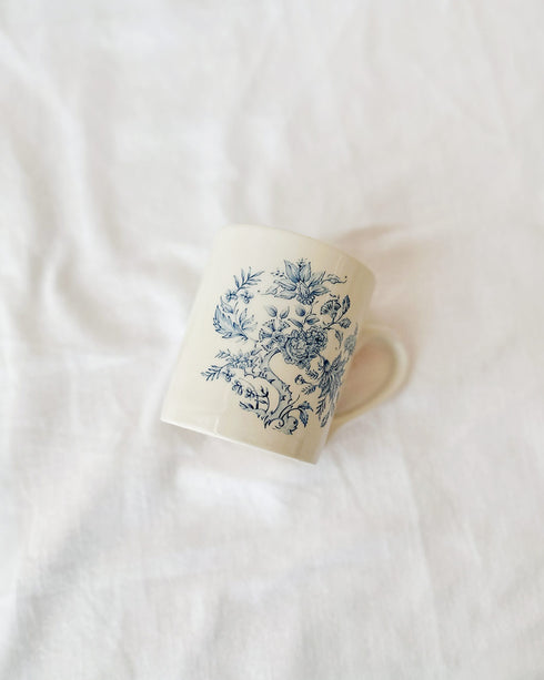 Ceramic mug with blue floral pattern on a white surface